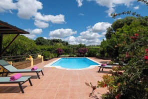A swimming pool with lounge chairs and a pergola, surrounded by lush greenery and flowering plants. - Casa de la Fuente - Two Bedroom Villa, Sleeps 4 (Vejer de la Frontera)