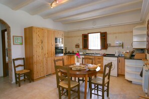 Enjoy cooking in this well-equipped kitchen with a central island, dining table, and window offering a view of the outside.
