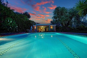 A swimming pool with a tiled deck and a building in the background. - Casa Buganvilla - Two Bedroom Villa, Sleeps 4 (Órgiva)