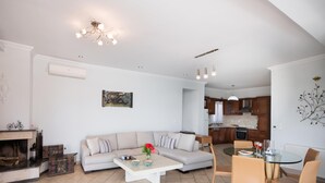 En moderne stue med sofa, sofabord og spiseområde med stole.
