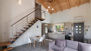 Un interior moderno con una escalera de madera, un comedor y una cocina.