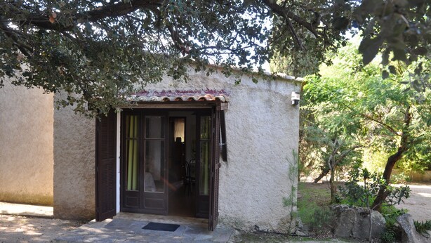 Un piccolo edificio con tetto in tegole e una porta con pannelli di vetro.