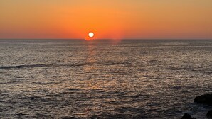 Ein Sonnenuntergang über einem ruhigen Meer mit klarem Horizont.