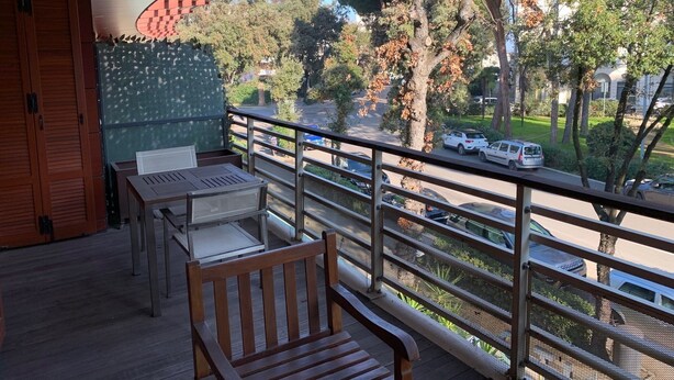 A balcony with a view of a street and trees. - Elegant apartment in the seaside park in Marina Centro (Rimini)