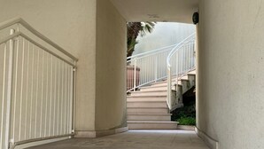 A set of concrete stairs leading up to a landing with a white railing. - Elegant apartment in the seaside park in Marina Centro (Rimini)
