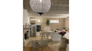 A modern kitchen with a stone backsplash, stainless steel appliances, and a central island with bar stools. - Mas de Sophie (Châteaurenard)