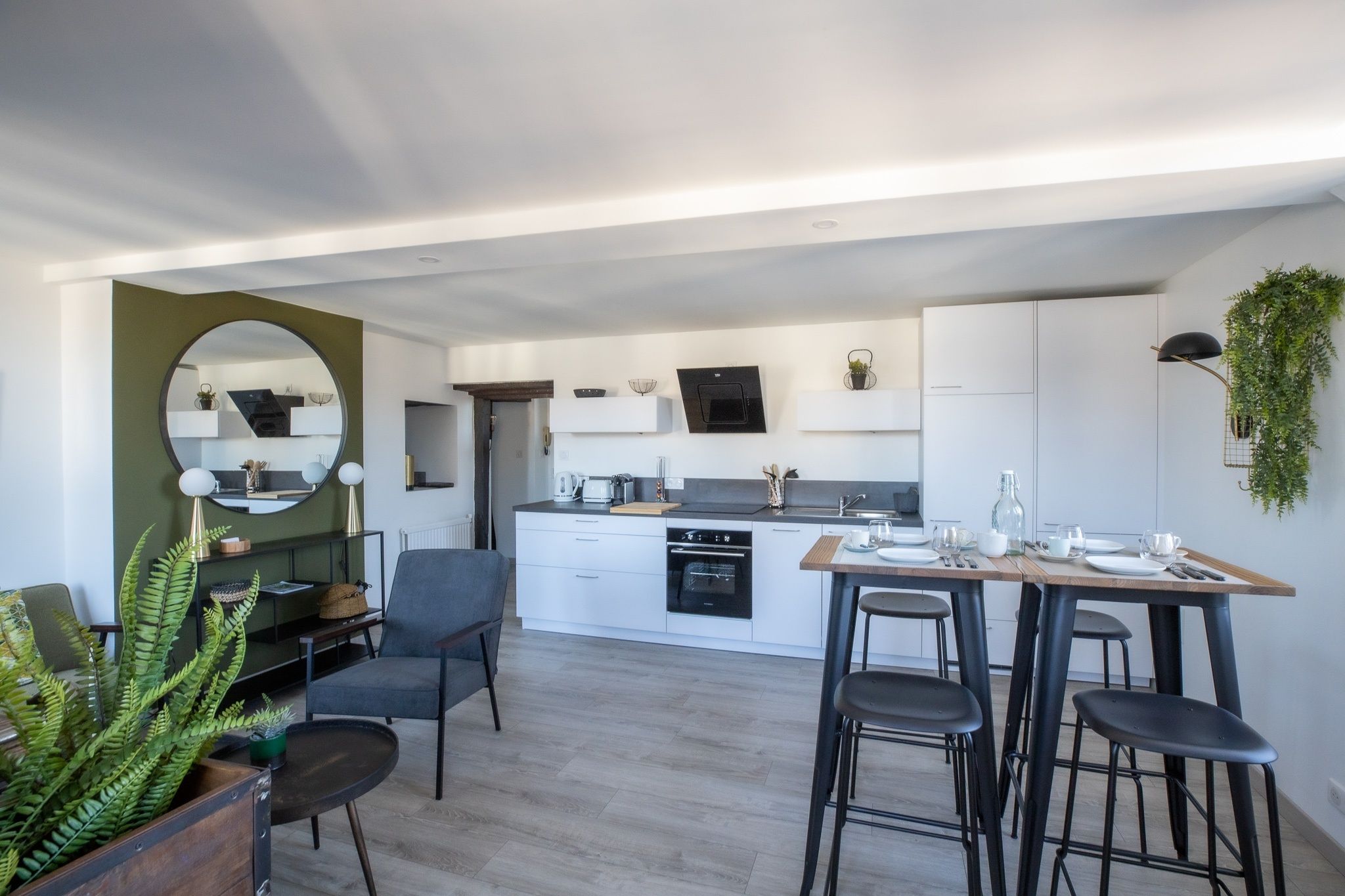 A modern kitchen with white cabinetry, a central island, and bar stools.