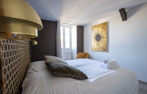 A hotel room with a bed, a chair, a wall-mounted artwork, and a window. - Le Saint-Georges - Splendide T3 centre de Vannes (Vannes)