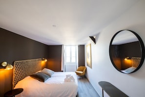A modern hotel room with a large bed, a round mirror, a chair, and a window. - Le Saint-Georges - Splendide T3 centre de Vannes (Vannes)