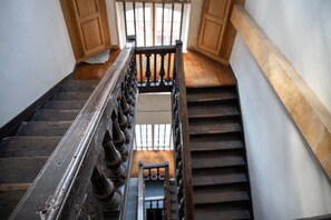 Una scala in legno con ringhiera che conduce a un piano superiore.