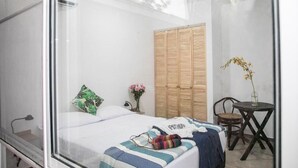 A bedroom with a bed, a wardrobe, a small table with a chair, and a potted plant. - 50N15 B&B (Cali)