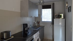 Uma cozinha compacta equipada com máquina de lavar, micro-ondas e torradeira.