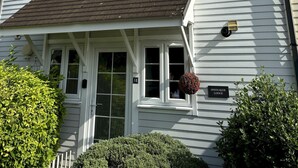 Un edificio de dos pisos con un porche cubierto, una chimenea y un cartel que dice 'Spinnaker Lodge'.