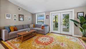 A living room with a grey sofa, a wooden coffee table, and a colorful rug.
