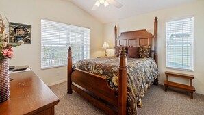 A bedroom with a four-poster bed, a ceiling fan, and two windows with blinds. - Above the Rest B301:  A spacious penthouse with water views (Cedar Key)