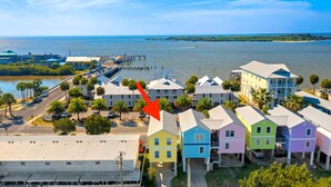 A coastal area with colorful houses, a pier, and a view of the ocean.