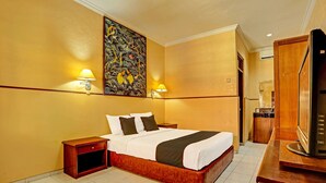 A hotel room with a large bed, two bedside tables, a wall-mounted TV, and a painting above the bed. - Collection O 91081 New Arena Hotel (Kuta)