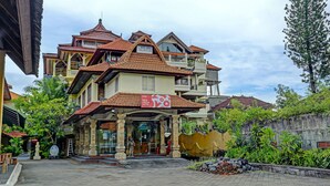 A hotel with a traditional architectural style, featuring multiple balconies and a prominent entrance. - Collection O 91081 New Arena Hotel (Kuta)