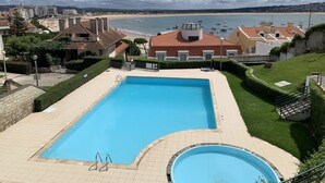 Une piscine avec vue sur la plage et les bateaux.