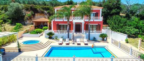Une villa à deux étages dotée d’une piscine, d’un patio couvert et d’un jardin luxuriant.