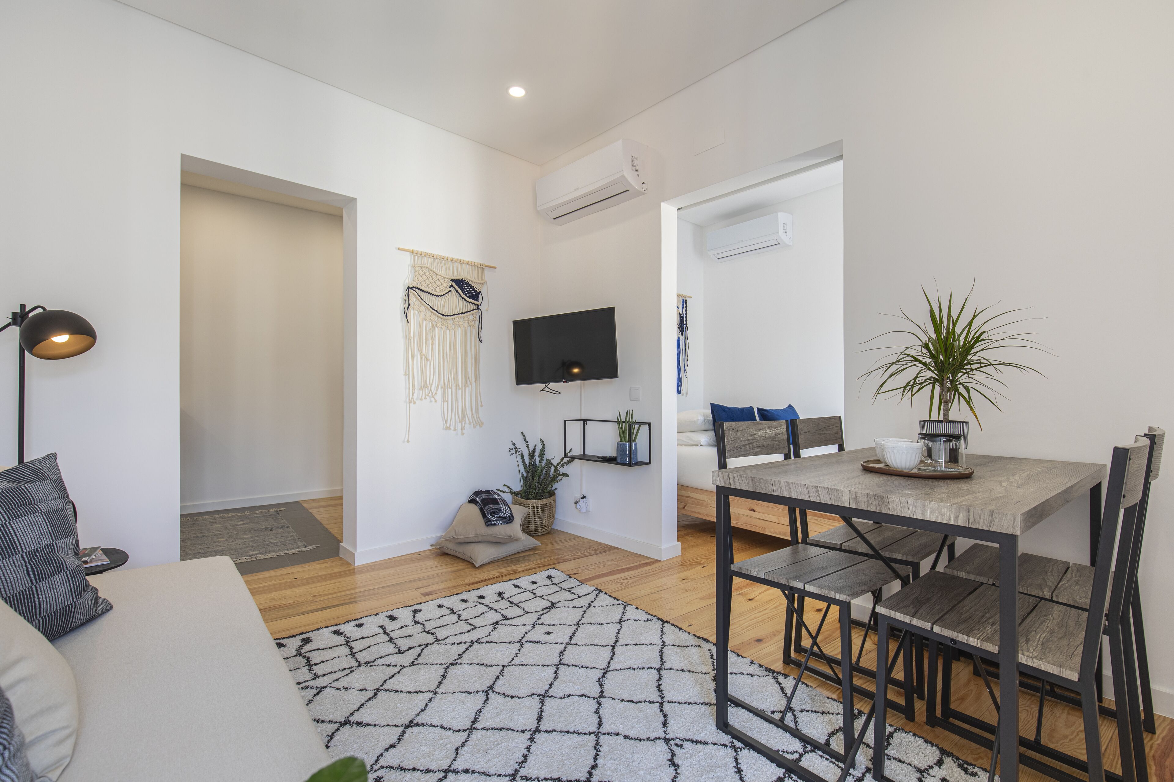 A modern living room with a sofa, a coffee table, and a dining area with a table and chairs.