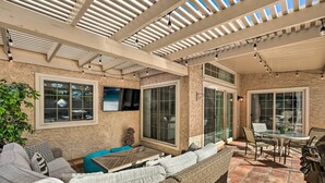 An outdoor patio with wicker furniture, a glass table, and a grill. - Near Golf! Snowbird Poolside Escape in Scottsdale (Scottsdale)