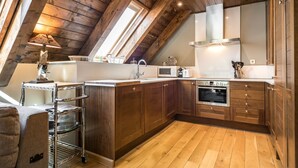 Eine Küche mit Holzausstattung, einem Edelstahlbackofen und einem Oberlicht.