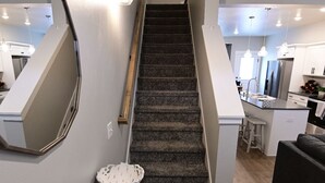 A staircase leading to a kitchen area with a countertop displaying snacks. - Cozy townhome (Billings)