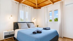 Un dormitorio con cama, mesita de noche y ventana con cortinas.