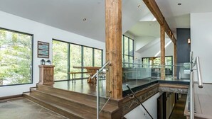 A modern interior with a staircase, large windows, and a view of the outdoors. - Cherry Island Muskokas Premiere Private Island (Utterson)