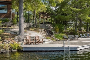 A wooden deck with chairs and a gazebo overlooking a body of water, surrounded by trees. - Cherry Island Muskokas Premiere Private Island (Utterson)