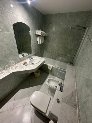 A bathroom with a sink, mirror, towel rack, shower, and bidet. - Mounia (Fes)