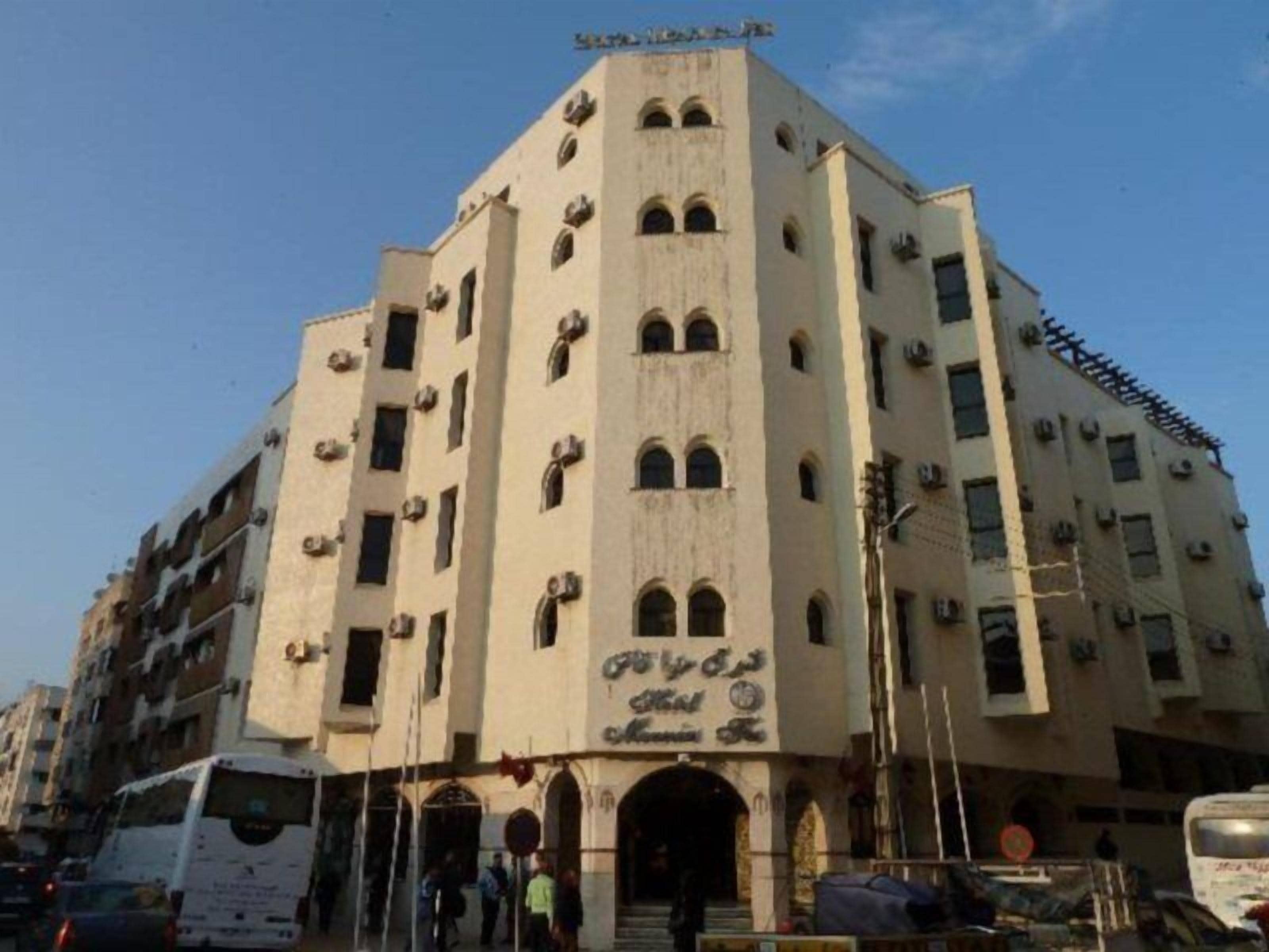 A multi-story building with arched windows and a sign in a foreign script.