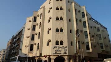 A multi-story building with arched windows and a sign in a foreign script.