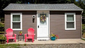Une maison à deux étages avec un porche à l’avant, deux fenêtres et une porte ornée d’une guirlande.