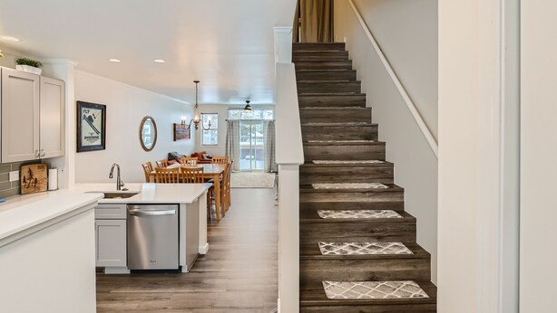 A modern kitchen with a wooden staircase leading to a dining area. - 2-BD 3-BDR Ski Cabin (Silverthorne)