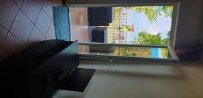 Enjoy a room with a large window offering a view of an outdoor area and lush greenery.