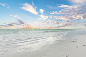 Une plage avec un ciel dégagé et une mer calme.