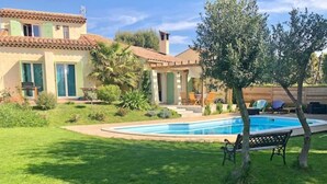 A house with a swimming pool, a patio with chairs, and a small garden. - Architect-designed villa with swimming pool and large garden (Marseille)