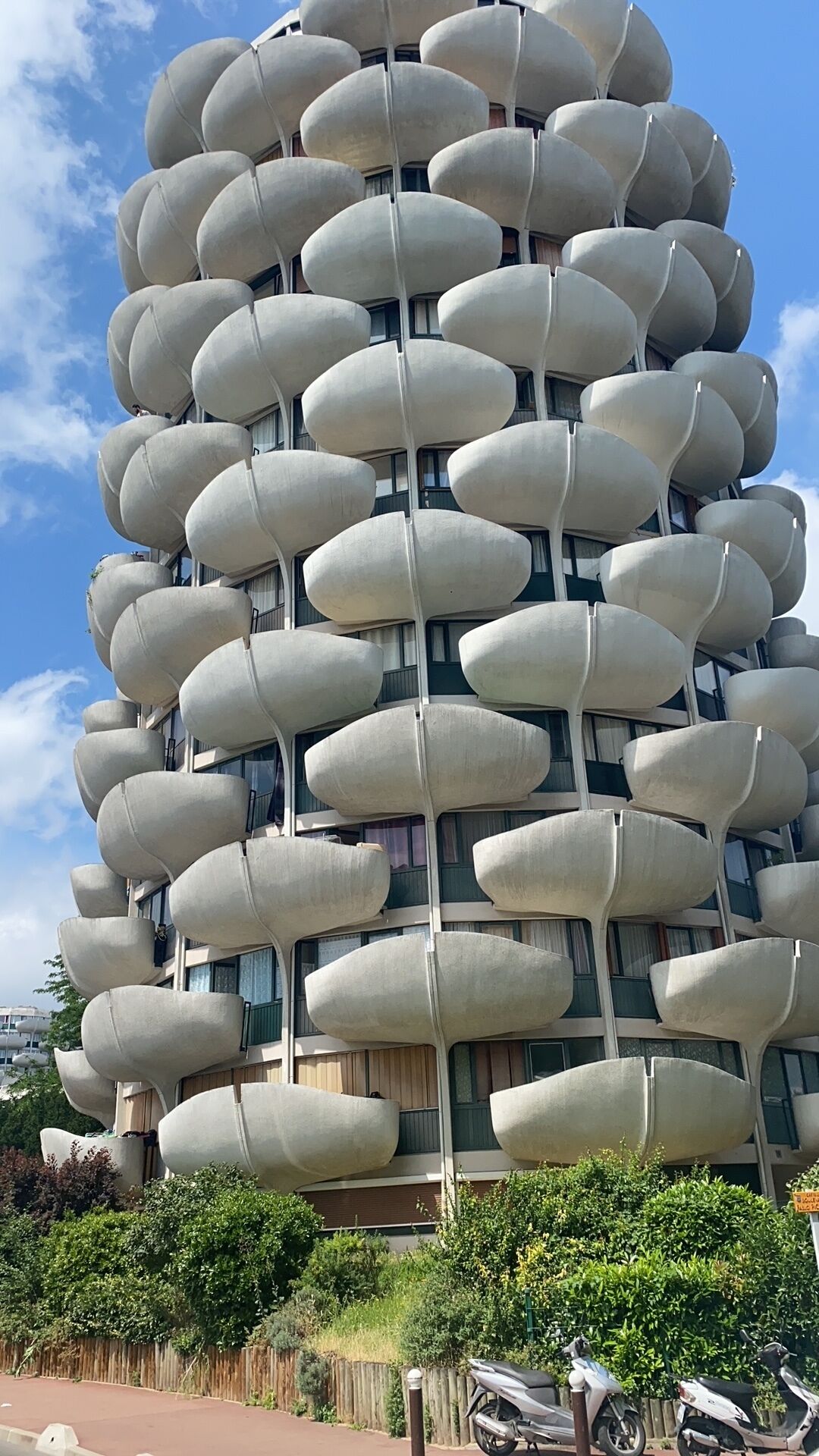 Um edifício moderno com design arquitetônico único e varandas arredondadas.