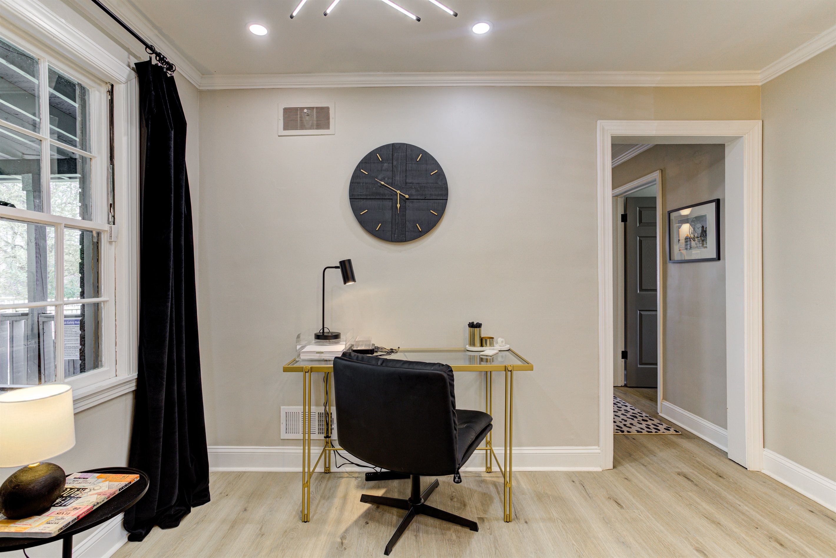 A modern office space with a desk, chair, and a round wall clock.