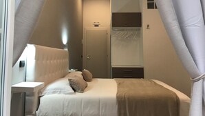 A bedroom with a bed, bedside table, and a wardrobe. - Base Napoli Plebiscito (Naples)