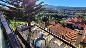 A balcony with a hot tub, a tree, and a view of a mountain and houses. - SLEEP AND GO - SANTANA IN NATURE B&B (Santana)