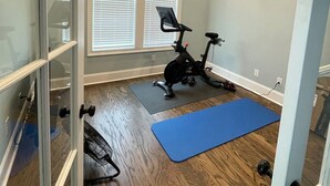 A room with a ceiling fan, exercise bike, and exercise mat. - Beautiful Masters Rental Quiet Neighborhood (EVANS)