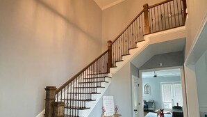 A spacious staircase with wooden railings and a white wall. - Beautiful Masters Rental Quiet Neighborhood (EVANS)