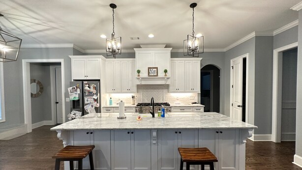 A spacious kitchen with a large island, white cabinetry, and two pendant lights. - Beautiful Masters Rental Quiet Neighborhood (EVANS)