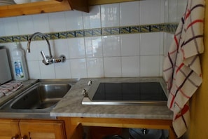 A kitchen with a double sink, a stove, and a tiled backsplash. - Las Brisas I and II Apartments (Ciutadella de Menorca)