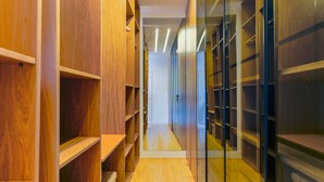 A narrow hallway with wooden shelving units on both sides and a glass partition on the right. -  2BR Chic&Bright com 120m2 em Campo de Ourique (Lisbon)