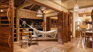A spacious room with a hammock, wooden furniture, and a thatched ceiling. - Sempre Vivo (Tibau do Sul)