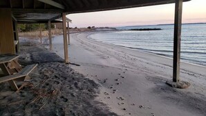 A beach with a wooden structure providing shade. - Coastal Farmhouse Getaway! (White Stone)
